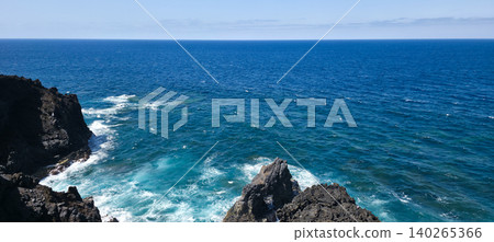 Rocky coastline with waves crashing against dark cliffs, showcasing the vast ocean and horizon in a serene natural landscape. High quality photo Rocky coastline with waves crashing against dark cliffs, showcasing the vast ocean and horizon in a serene natural landscape. High quality photo 140265366