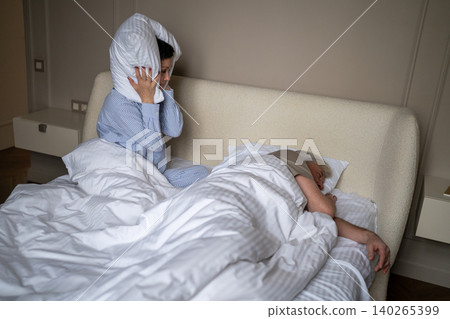 Annoyed senior woman suffering from depression and frustration caused by older husband snoring. Annoyed senior woman suffering from depression and frustration caused by older husband snoring. 140265399