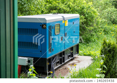 Hi-tech modern electric generator device standing outdoors at backyard near residential house. Hi-tech modern electric generator device standing outdoors at backyard near residential house. 140265438