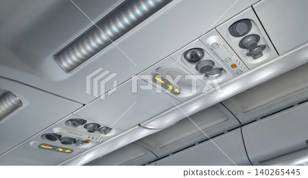 The airplane panel above the passengers with indicators for the need to fasten the seatbelt, the air conditioning system, and the call buttons for the flight attendant. High quality photo The airplane panel above the passengers with indicators for the need to fasten the seatbelt, the air conditioning system, and the call buttons for the flight attendant. High quality photo 140265445