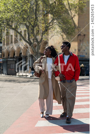 Happy african american students friends man and woman walking smiling through city road together. Happy african american students friends man and woman walking smiling through city road together. 140265453