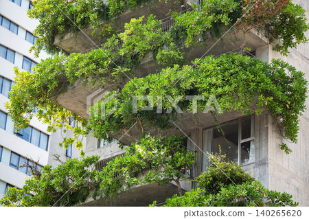 Building with vertical garden, balconies filled with greenery cascading from apartment terraces. Building with vertical garden, balconies filled with greenery cascading from apartment terraces. 140265620