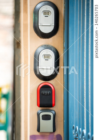 Various lock boxes with keys code inside located on wall near entrance gate at apartment building. Various lock boxes with keys code inside located on wall near entrance gate at apartment building. 140265703