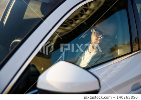Tired business man falling asleep sitting inside her car seen through windshield Tired business man falling asleep sitting inside her car seen through windshield 140265856