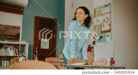 Happy Hispanic mid adult female teacher standing and smiling in a school classroom Happy Hispanic mid adult female teacher standing and smiling in a school classroom 140265934