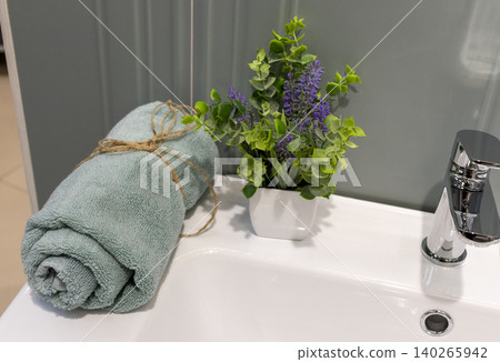 Modern Bathroom Basin Detail with Rolled Towel and Potted Lavender Plant 140265942