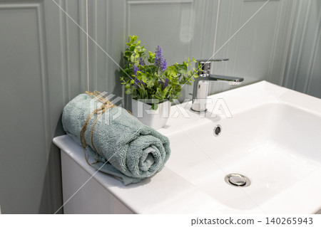 Modern Bathroom Basin Detail with Rolled Towel and Potted Lavender Plant 140265943
