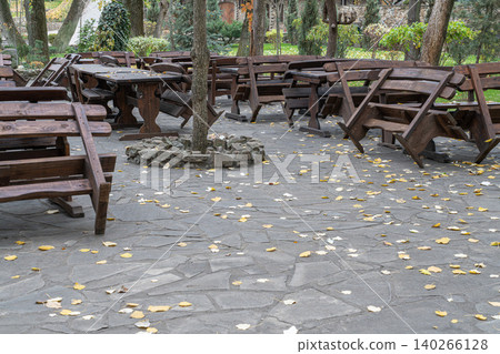 Outdoor seating area with wooden tables and chairs 140266128