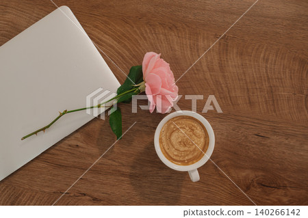 flat lay of coffee, pink rose, and closed laptop: cozy atmosphere for autumn remote work flat lay of coffee, pink rose, and closed laptop: cozy atmosphere for autumn remote work 140266142