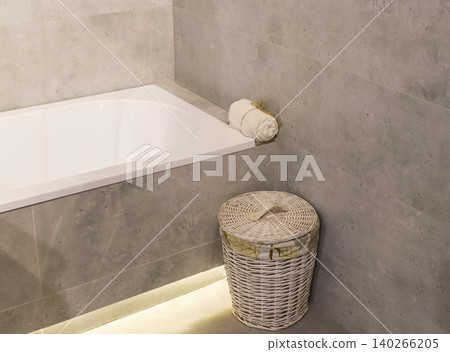 White Acrylic Bath Corner with Rolled Towel and Woven Hamper on Floor White Acrylic Bath Corner with Rolled Towel and Woven Hamper on Floor 140266205
