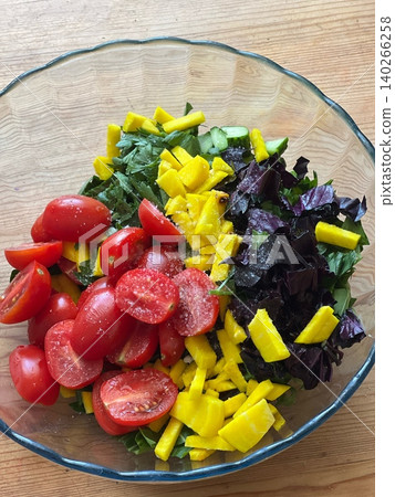 Fresh vegetable salad with tomatoes, mango, and herbs in glass bowl Fresh vegetable salad with tomatoes, mango, and herbs in glass bowl 140266258