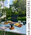 Breakfast table setting with tea, bread, and vegetables in garden 140266341