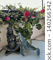 Decorative figurine of a woman and whale beside blooming roses in a 140266342