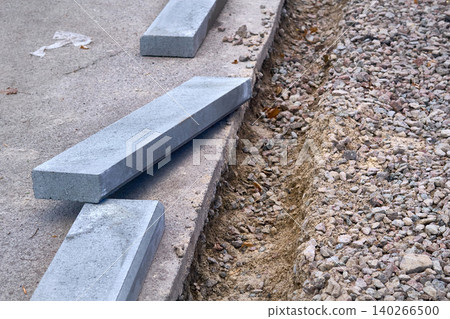 Beginning.Roadbed with border stone prepared for asphalt laying Beginning.Roadbed with border stone prepared for asphalt laying 140266500