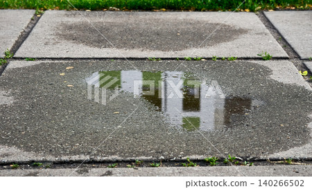 Calm after rain.Puddle on concrete pedestrian slabs Calm after rain.Puddle on concrete pedestrian slabs 140266502