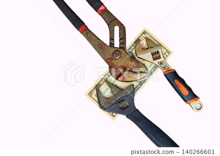 Paying.Ten dollars bill between old adjustable wrenches 140266601