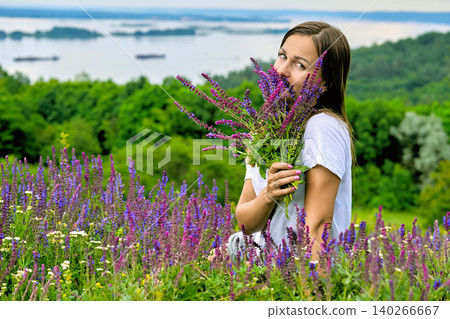 Cute young woman picking bouquet of medic herbs. Sage flowers and greenery Cute young woman picking bouquet of medic herbs. Sage flowers and greenery 140266667