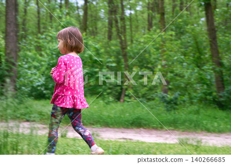 Blurred motion.Little girl in red dress walking on country forest road Blurred motion.Little girl in red dress walking on country forest road 140266685