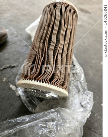 Worn Hydraulic Oil Filter Resting on Plastic in a Workshop Area 140266841