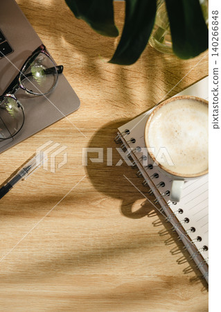 Home office workspace with open notebook, coffee and eyeglasses on wooden desk, top view with copy space Home office workspace with open notebook, coffee and eyeglasses on wooden desk, top view with copy space 140266848