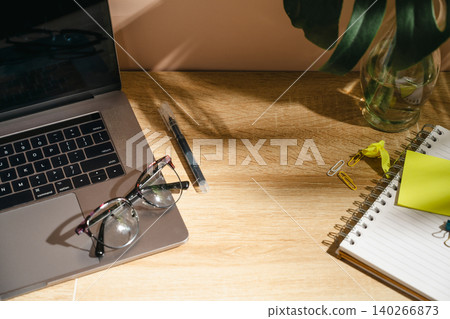 Home office workspace with coffee, laptop and notebook on wooden desk, top view mockup with copy 140266873
