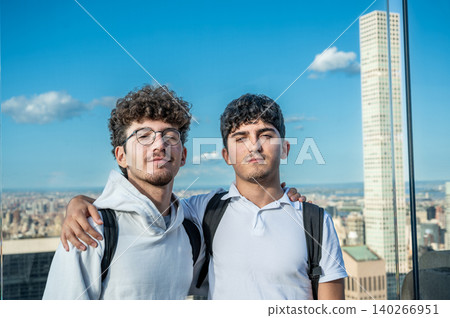 New york, usa august 21,2024. Two young male tourists embracing on a high observation deck with manhattan skyline and empire state building behind them New york, usa august 21,2024. Two young male tourists embracing on a high observation deck with manhattan skyline and empire state building behind them 140266951