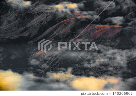 Aerial view of mountain landscape at sunset from airplane window Aerial view of mountain landscape at sunset from airplane window 140266962