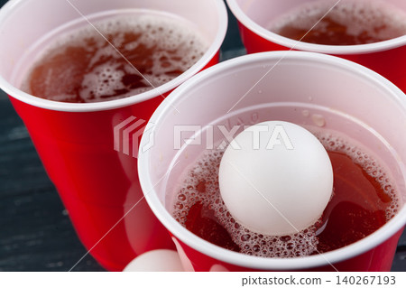 Wooden table with red cups and ball for beer pong Wooden table with red cups and ball for beer pong 140267193