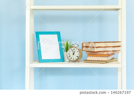 White metal rack with books against blue background 140267197