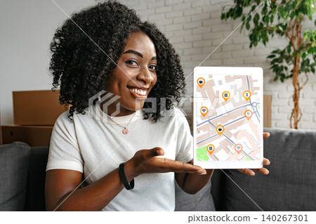 Woman shows travel route on digital map in indoor space while sitting on a couch Woman shows travel route on digital map in indoor space while sitting on a couch 140267301