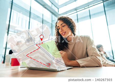 Woman checks travel map on laptop in cafe while planning her taxi ride to a location Woman checks travel map on laptop in cafe while planning her taxi ride to a location 140267303