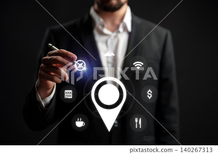 Man holds pen near map icon while planning a taxi route in a city setting at night Man holds pen near map icon while planning a taxi route in a city setting at night 140267313