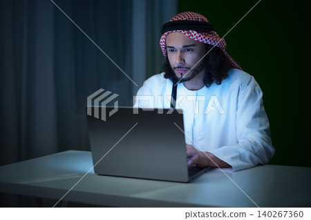 Man works late on laptop in dark room during night hours Man works late on laptop in dark room during night hours 140267360