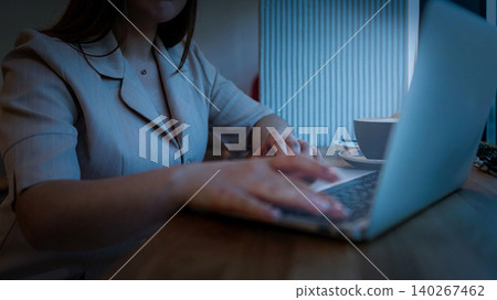 Writing on a laptop with a cup of coffee during evening hours in a quiet cafe Writing on a laptop with a cup of coffee during evening hours in a quiet cafe 140267462