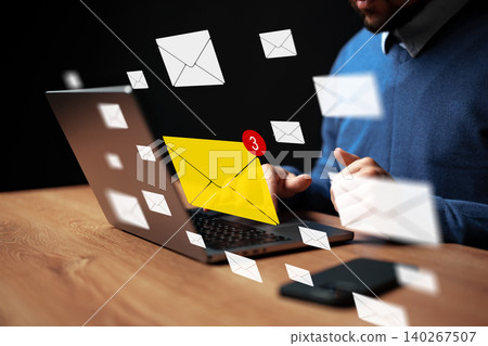 Message notifications appear on computer while a man works at a desk during morning hours Message notifications appear on computer while a man works at a desk during morning hours 140267507