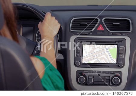 Driver using a GPS map to find a taxi location in the city while driving Driver using a GPS map to find a taxi location in the city while driving 140267573