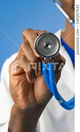 Doctor holds stethoscope ready for patient checkup in a medical setting 140267643