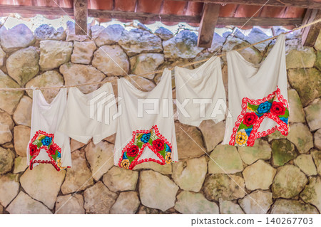 Embroidered garments and handmade textiles hang outdoors, showing local craft, folk clothing, cultural heritage and travel detail concept Embroidered garments and handmade textiles hang outdoors, showing local craft, folk clothing, cultural heritage and travel detail concept 140267703