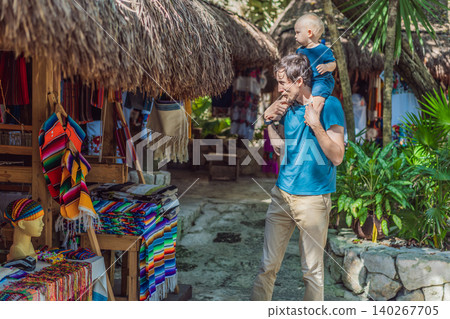 Dad walks with his infant on his shoulders among lush plants, showing fatherhood, travel with baby, jungle adventure and family vacation concept Dad walks with his infant on his shoulders among lush plants, showing fatherhood, travel with baby, jungle adventure and family vacation concept 140267705