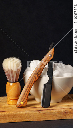 Wooden razor and shaving brush with cream on wooden board in a dark setting Wooden razor and shaving brush with cream on wooden board in a dark setting 140267758