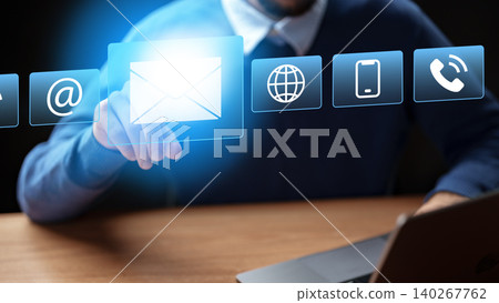 Man checking messages at desk while using laptop and digital icons on screen Man checking messages at desk while using laptop and digital icons on screen 140267762