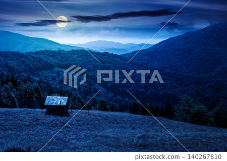 view of mountain meadow at night. full moon over countryside summertime landscape with beech forest on the grassy field on hill. dark sky. mysterious alpine background for travel through highland view of mountain meadow at night. full moon over countryside summertime landscape with beech forest on the grassy field on hill. dark sky. mysterious alpine background for travel through highland 140267810