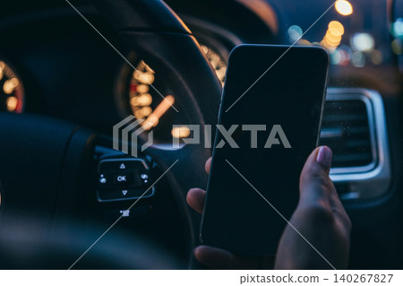 Scam message appears on a phone while driving at night on a busy street Scam message appears on a phone while driving at night on a busy street 140267827