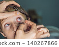 Close up of a boy during vision screening shows pediatric healthcare, ophthalmology, eyesight testing and child health concept 140267866