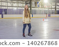 Woman ice skating alone at indoor rink, practicing winter sport, balance, active lifestyle and recreation in a bright public skating arena concept 140267868