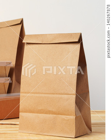Craft paper bag placed on a wooden surface in a simple indoor setting during daylight 140267878