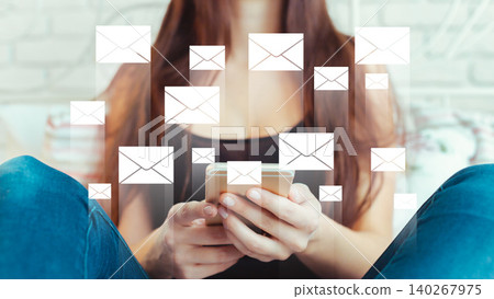 Messages and news notifications on a phone screen held by a person sitting indoors 140267975