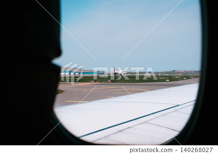 Aircraft on runway seen from airplane window during flight departure Aircraft on runway seen from airplane window during flight departure 140268027