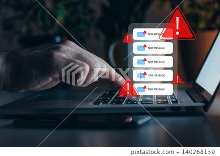 Scam message warning appears on laptop screen while user checks inbox at home office 140268139