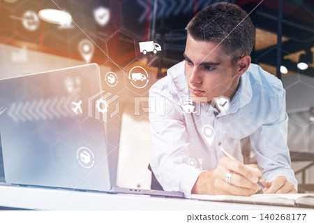 Logistics professional analyzes data and makes notes at work in an office setting Logistics professional analyzes data and makes notes at work in an office setting 140268177